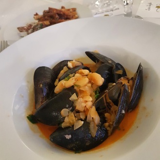 a bowl of mussels with chorizo and white beans